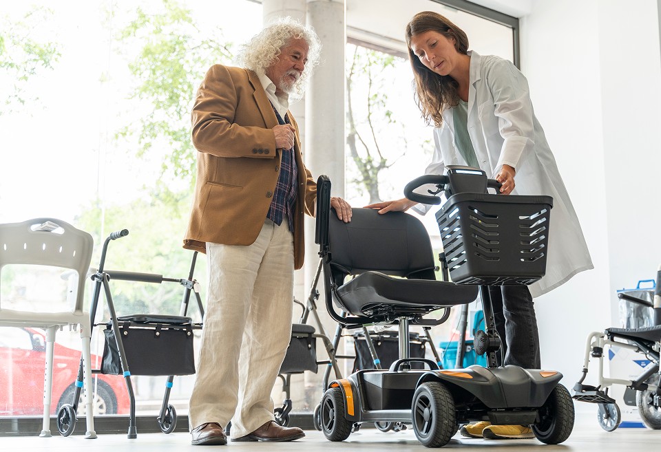 Healthcare professional helping a patient choose a mobility scooter