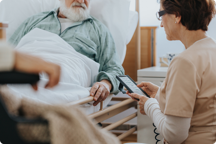 Caregiver adjusting a hospital bed for a patient at home